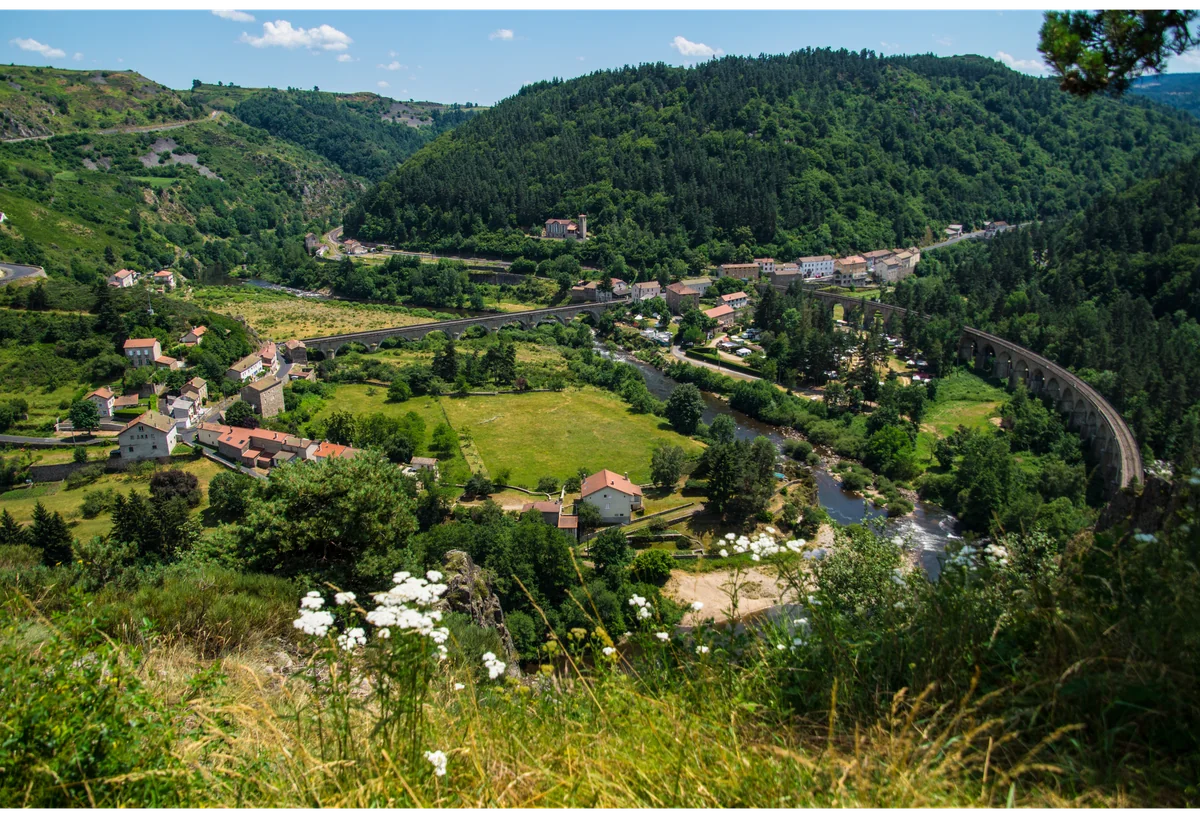 Paysage naturel de Haute-Loire avec village, vallée, rivière et viaducs entourés de collines verdoyantes